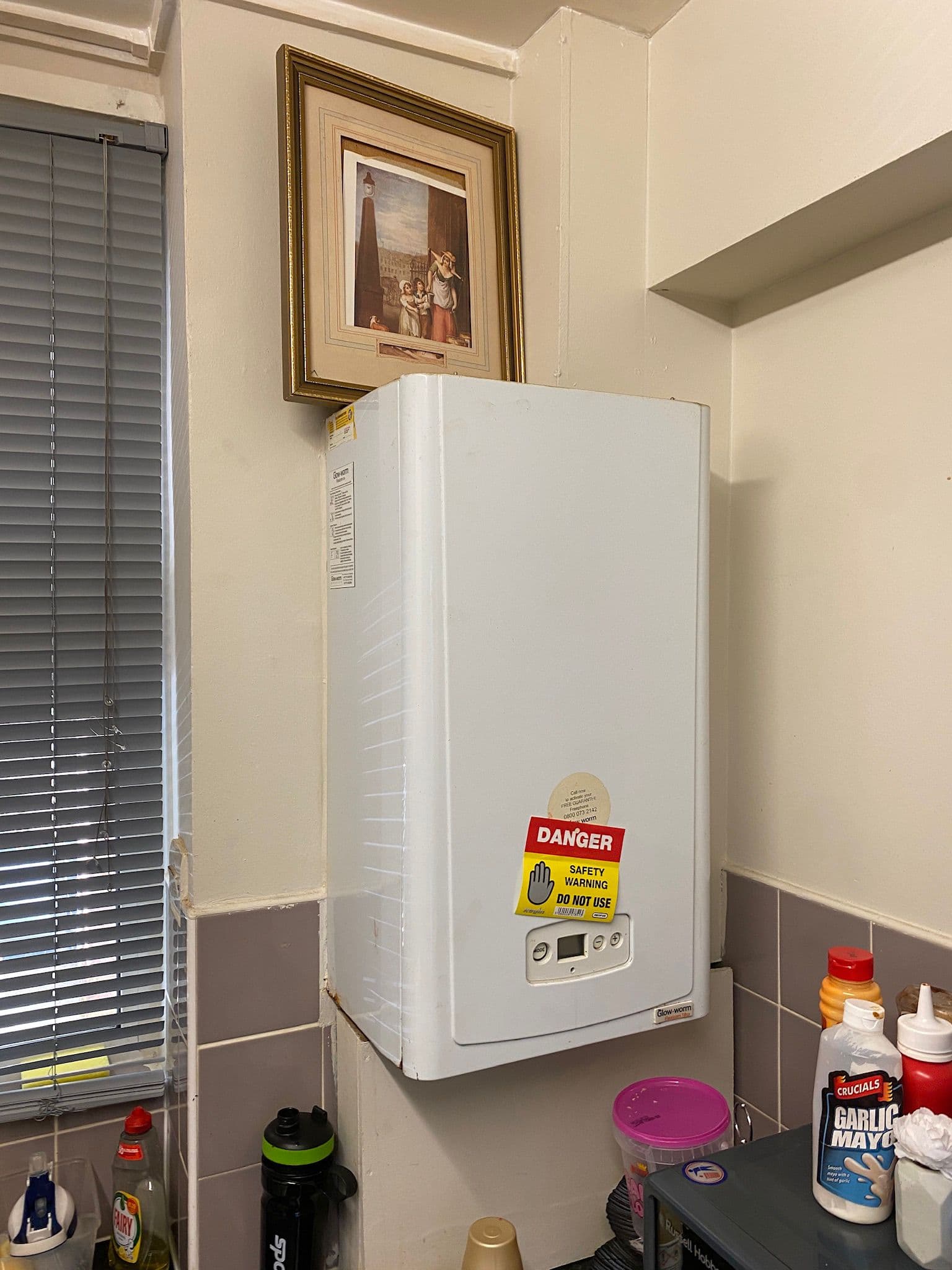 Old boiler with danger tag requiring replacement in North Finchley